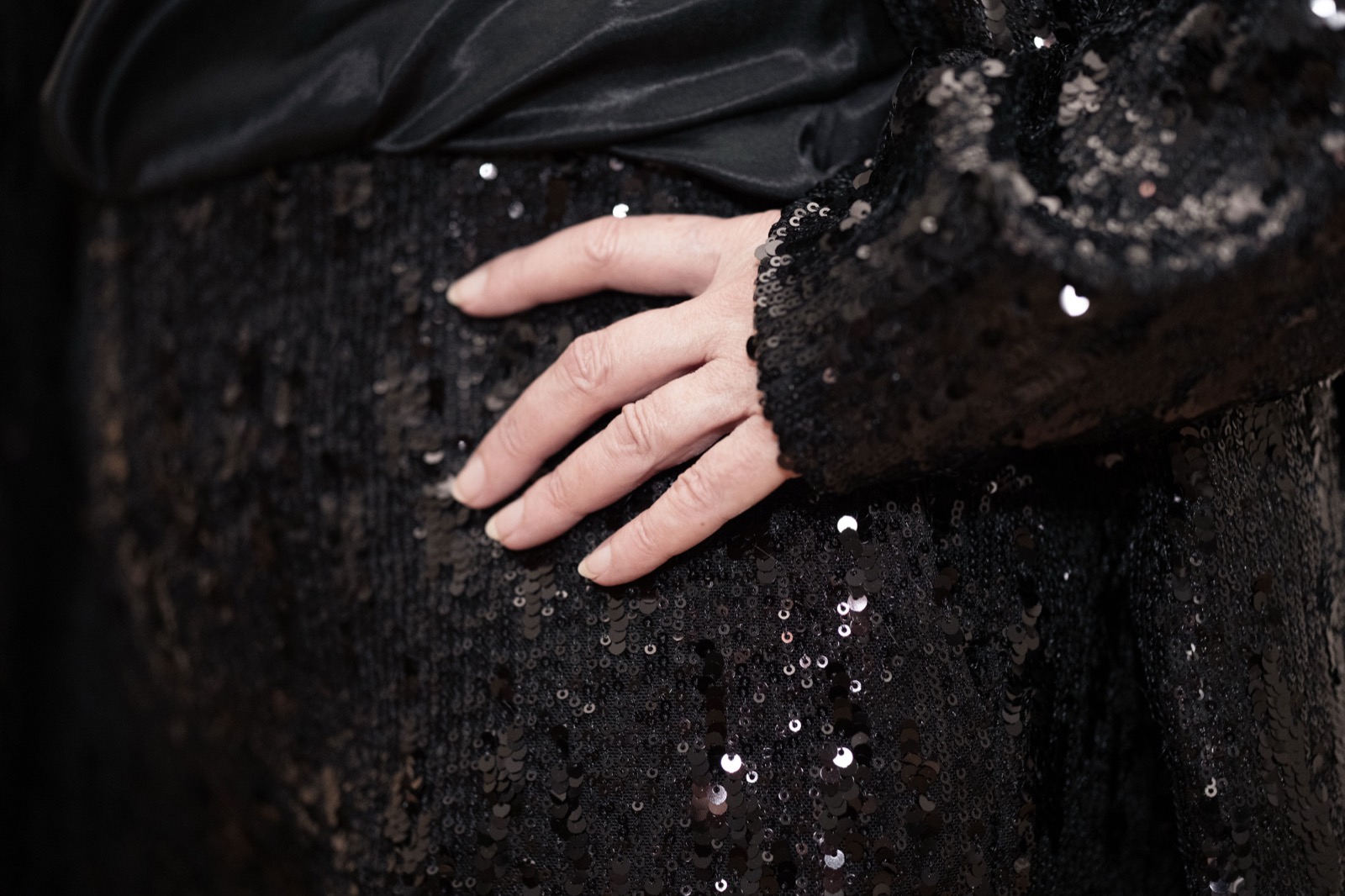 Detail of Maria Kempinska's hand resting on a black sequinned dress